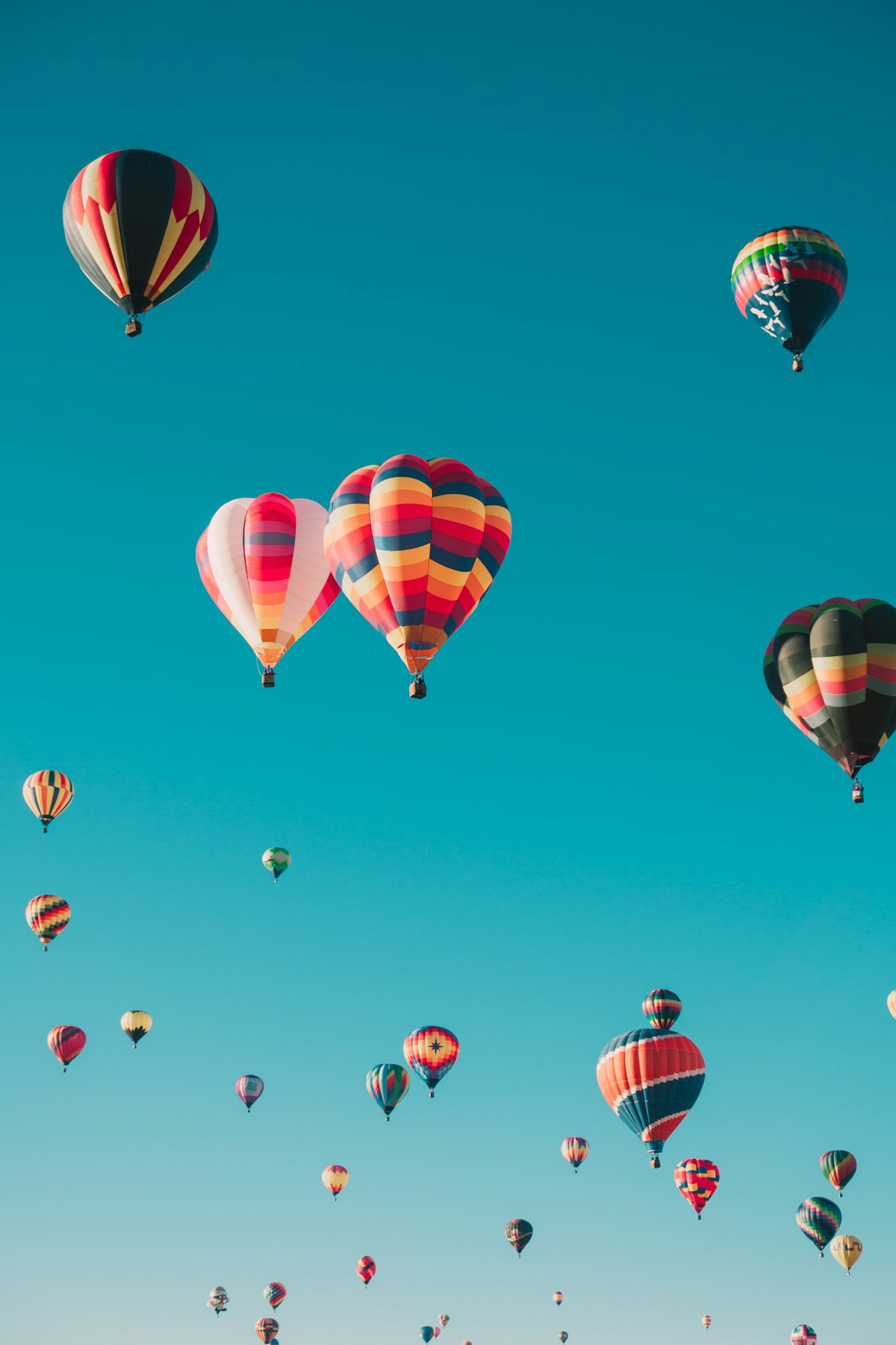Hot air balloons flying over Cappadocia rock formations at sunrise